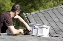 a handyman clears out a gutter